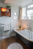 Rolltop-Badewanne aus Gusseisen und Wackelmatte in einem Badezimmer im Landhausstil in Hampshire (UK)