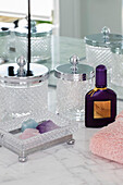 Vorratsgläser aus geschliffenem Glas und Parfüm im Badezimmer eines Londoner Stadthauses UK