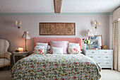 Floral bedspread in pastel pink bedroom Grade II listed Georgian country house West Sussex UK