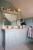 Lit candles on shelf above washbasin with woodwork in Stock by Little Greene Grade II listed Georgian country house West Sussex UK