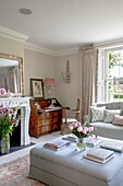 Elegantes Wohnzimmer mit frischen Schnittblumen und hellrosa und cremefarbenen Möbeln Hampshire UK