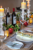 Kerzen und Wein mit Granatäpfeln auf einem Gedeck in einem Landhaus in Surrey UK