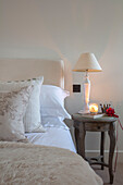 Beleuchtete Kerze mit Lampe am Bett in einem Landhaus in Surrey UK