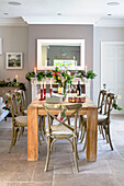 Holztisch und -stühle mit Weihnachtsblättern und Blumen geschmückt Hampshire UK