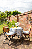 Table and chairs on brick garden terrace Surrey UK