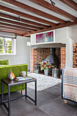 Grünes Sofa und Beistelltisch in einem Cottage mit Holzbalken in Surrey, UK