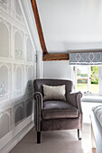 Upholstered armchair with light grey wallpaper Surrey UK