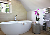 Freistehende Badewanne und rosa Orchidee Surrey UK
