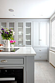 Grey kitchen units and flower arrangement London UK