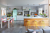 Open plan kitchen with light green fridge and pink chairs Sussex UK