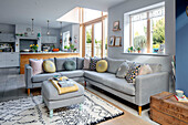 Light grey corner sofa and ottoman in open plan living room Sussex UK