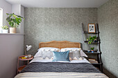 Schlafzimmer mit gemusterter Tapete und freistehenden Regalen Sussex UK