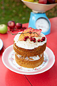 Berries and autumn leaves on sponge cake with baking scales in Isle of Wight garden UK