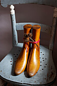 Vintage wooden shoehorns on weathered chair in Isle of Wight home UK