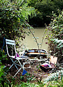 Rowing boat moored on riverbank with folding chair bunting and wool Isle of Wight, UK