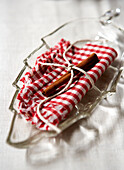 Red and white checked napkin with cinnamon stick on glass dish in Isle of Wight home UK