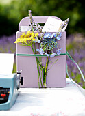 Schnittblumen und Schreibmaschine auf einem Tisch im Garten auf der Isle of Wight, UK
