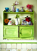 Single stem vases on green painted wall unit in Isle of Wight home UK