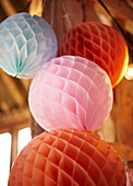 Paper baubles in pink orange and blue in late summer