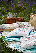 Floral cushions and picnic hampers in bluebell woods (Hyacinthoides non-scripta)