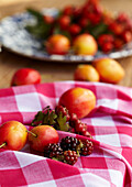 Red and white gingham cloth with Victoria Plums and blackberries