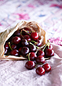 Paper bag with cherries on tabletop