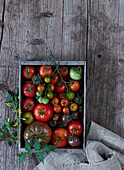 Assorted heirloom tomatoes in a wooden crate