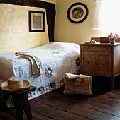 Gästezimmer mit amerikanischem Patchwork-Quilt und gestreiftem Eichenboden