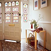 Eingangshalle mit gefliestem Boden und Buntglastür