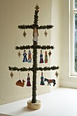 Alternativer kleiner Weihnachtsbaum auf dem Tisch, geschmückt mit hölzernen Krippenfiguren