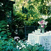 Pretty lunch time table setting in a leafy garden in summer time