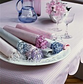 Mit Perlen verzierte Stoffservietten auf einer rosa Gingham-Tischdecke