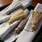 Group of neutral coloured napkins individually rapped with tassels trimming