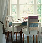 White dining room with large window and table setting