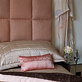Pink soft furnishings in a bedroom with upholstered bedhead