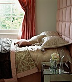 Rosa Möbel in einem Schlafzimmer mit gepolstertem Betthaupt