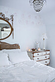 Schlafzimmer im skandinavischen Stil mit abgenutzter Lackierung und altem Bett und Kommode