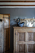Antique pine cupboard with ceramic swans and candles