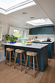 Fitted kitchen cabinets with kitchen counter, with cabinet fronts in petrol on a houseboat