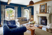 Spacious living room with fireplace and blue velvet furniture