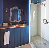 Dark blue bathroom with copper washbasin and shower