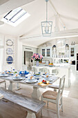 Country-style dining table with blue and white crockery and kitchen island