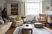 Rustic living room with cream-coloured upholstered furniture and sculpture