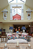 Wohnzimmer mit weißem Vintage-Sofa und indischen Wandregalen
