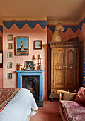 Schlafzimmer mit Kamin, Holzschrank und Wanddeko im Vintage-Stil