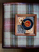 Tray with a cup of tea on tartan upholstery