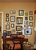 Antique desk below gallery of pictures