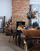 Dining area with rustic wooden table, fireplace and brick chimney