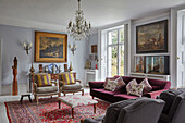 Elegant lounge with upholstered furniture, antiques and collection of paintings