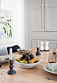 Set dining table with fruit bowl and candlesticks, school map